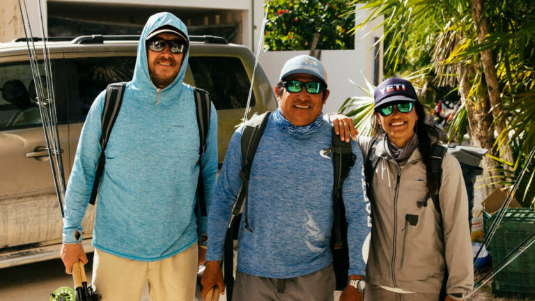 Jose Ucan and two guests take a group photo before fly fishing.