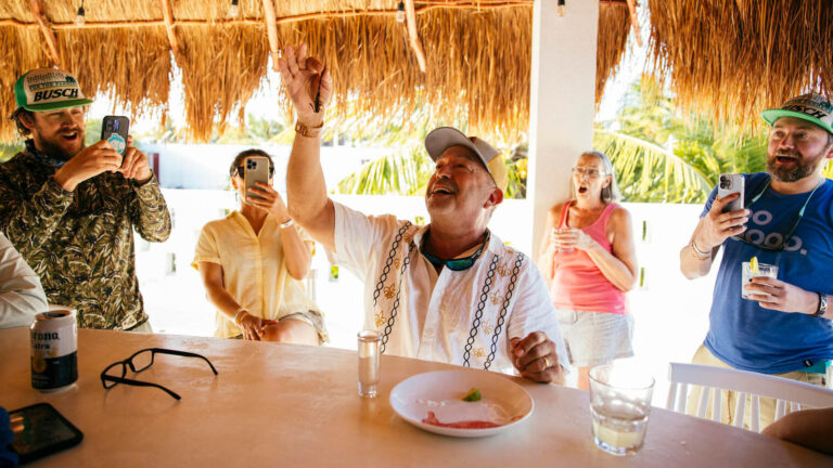 A guest at the Kay Fly Fishing Lodge Bar eating a scorpion.